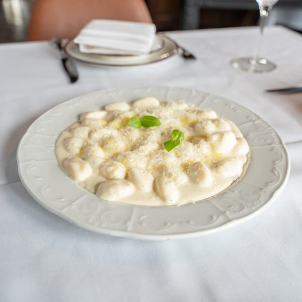 Antica Sicilia's gnocchi in a creamy white sauce, topped with grated cheese and basil.